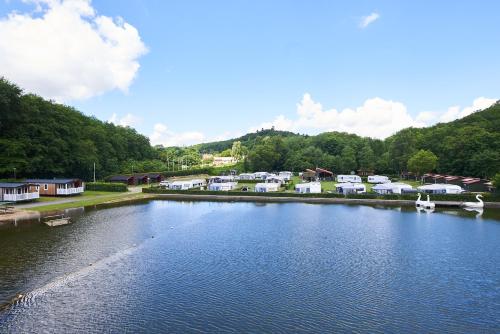 a river with a group of houses and a town at Randbøldal Camping & Cabins in Randbøl