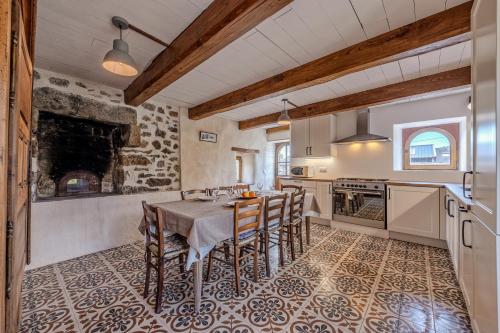 une cuisine avec une table et des chaises dans une pièce dans l'établissement Ty Forn - Maison à 10min des plages, à Plougastel-Daoulas
