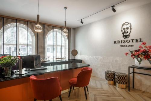 un restaurant avec un bar et des chaises orange dans l'établissement Krisotel, à Amsterdam