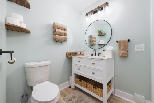 uma casa de banho com um WC branco e um espelho. em Channel Charmer - Located on Gun Lake - prime spot! em Shelbyville
