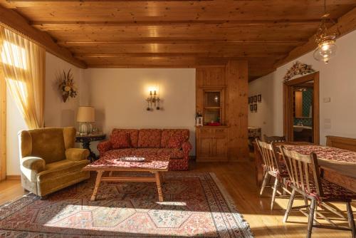 un soggiorno con un divano rosso e un tavolo di Casa Ciclamino, direttamente sul Corso di Cortina dAmpezzo a Cortina dʼAmpezzo