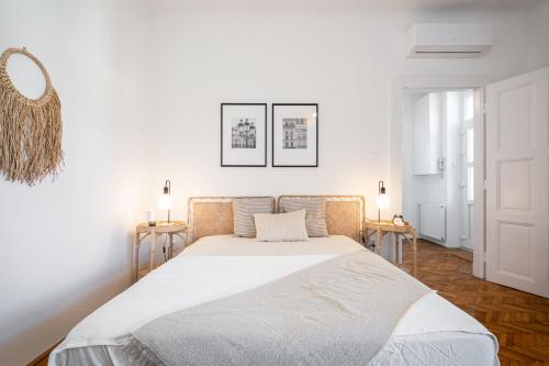 BpR NEO Rooftop Home with A/C في بودابست: غرفة نوم بيضاء مع سرير وطاولتين