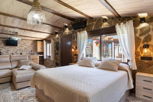 a bedroom with a large bed and a couch at Loft Abanderao Piscina y Jacuzzi in Conil de la Frontera