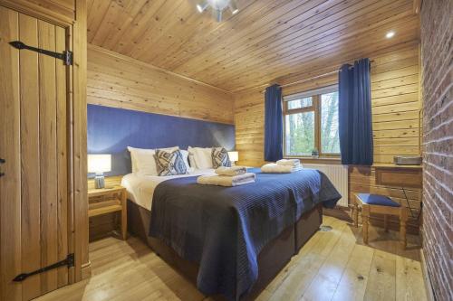 a bedroom with a bed in a wooden cabin at Chiffchaff Lodge with Hot tub in Carlisle