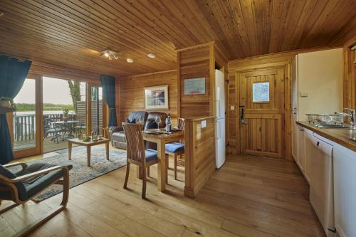 a kitchen and living room with a wooden ceiling at Chiffchaff Lodge with Hot tub in Carlisle