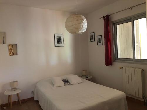 1 dormitorio con cama blanca y ventana en RDJ Proche mer "L'Oustaou Cabriole", en Saint-Cyr-sur-Mer