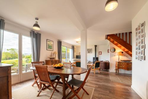 une cuisine et une salle à manger avec une table et des chaises dans l'établissement La maison aux volets bleus, à Arzon