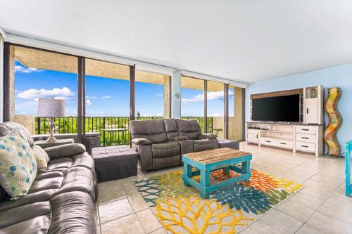 a living room with a couch and a tv at Our House at the Beach 502E By Beachside Management in Siesta Key