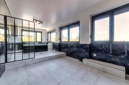 a bathroom with black and white tiles and windows at Villa Sunshine in Sremska Kamenica