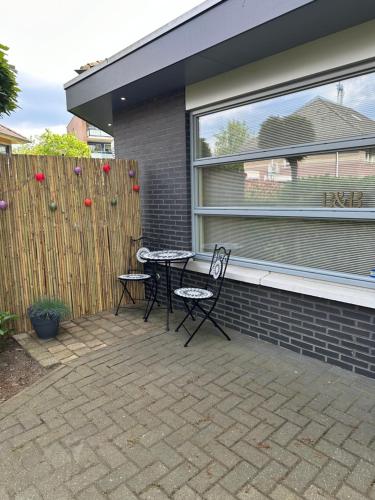 d'une terrasse avec deux chaises et une table devant une fenêtre. dans l'établissement B&B Twente, à Enschede