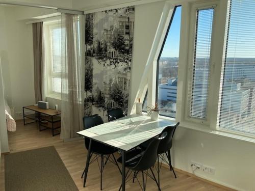 uma sala de jantar com uma mesa e cadeiras e uma janela em Topaasi em Tampere