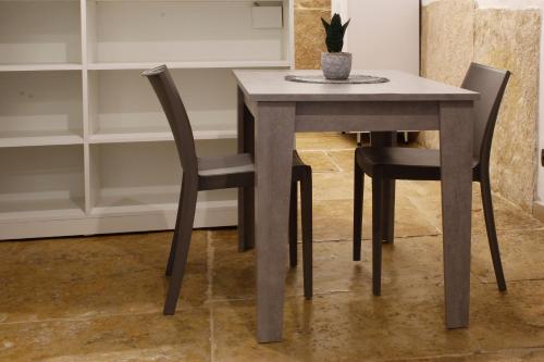a dining room table with two chairs and a potted plant at La perla casa vacanze in Barletta