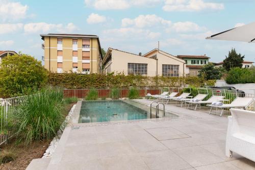 een zwembad met ligstoelen naast een gebouw bij Villa Fedora Luxury Suites in Lucca