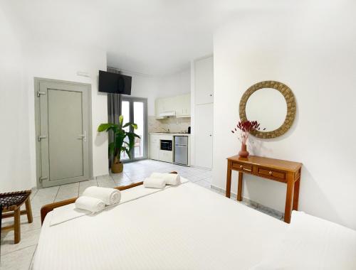 プラティスヤロス・シフノスにあるLemonia Rooms 1の白いベッドルーム(大型ベッド1台、鏡付)