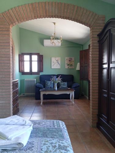 a living room with a blue couch and a table at Els Canterers in Miravet