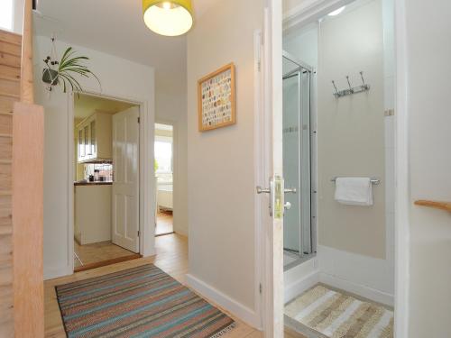 a bathroom with a walk in shower and a glass door at Sea Drift in St Austell