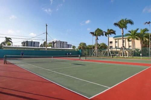 a tennis court with two people playing tennis at Palm Bay Club in Siesta Key