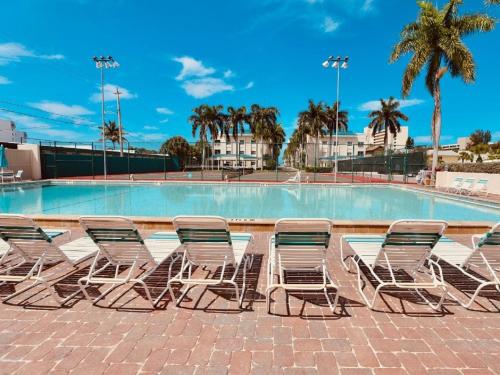 a group of chairs sitting next to a swimming pool at Palm Bay Club in Siesta Key