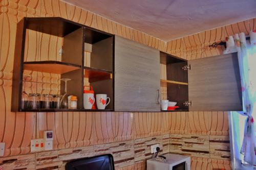 una cocina con paredes de madera y armarios de madera. en Shanzu Budget Traveler Homestay, en Mombasa