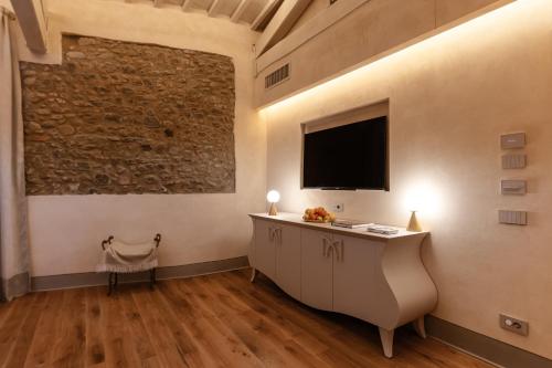 a room with a desk and a television on the wall at La Monastica Resort & Spa in Borgo a Buggiano