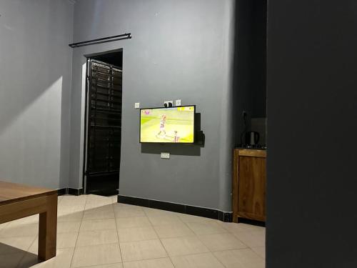 a tv on a wall with a video game on it at Maro Homestay Sango in Old Moshi