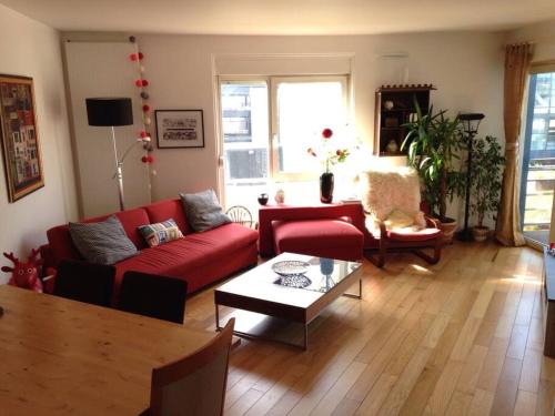 un salon avec un canapé rouge et une table dans l'établissement Joli 3 pièces + terrasse LaVillette, à Paris