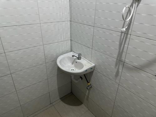 a bathroom with a sink in a white tiled wall at Maro Homestay Sango in Old Moshi
