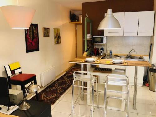 - une cuisine avec un comptoir et quelques chaises dans l'établissement DANIEL, à Marseille