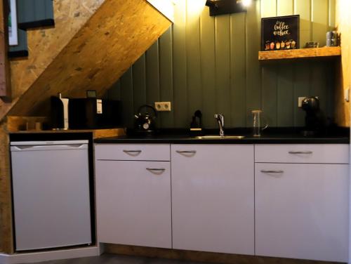 a kitchen with white cabinets and a sink at Mimosa bed & breakfast in IJsselmuiden in IJsselmuiden
