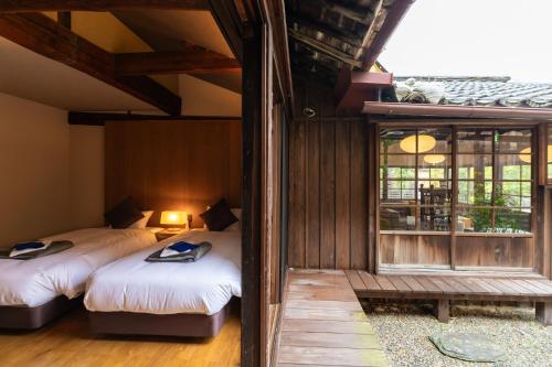 a bedroom with two beds and a window in it at PAYSAGE MORIGUCHI in Mima