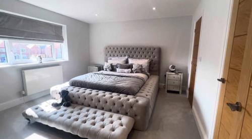 a bedroom with a large bed with a leather couch at Great holiday home for vacations & holidays in Tetney