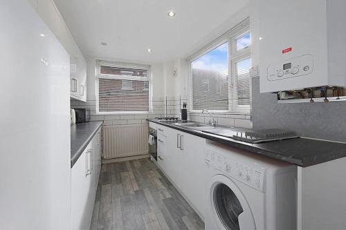 a white kitchen with a washer and dryer in it at Frances Terrace Haven in Bishop Auckland