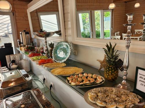 um buffet com muitos tipos diferentes de comida em um balcão em Twój Port em Krynica Morska