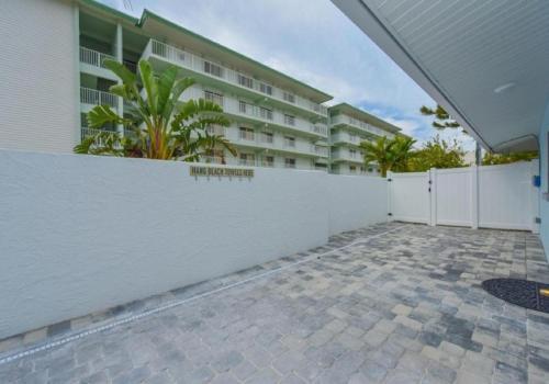 a white fence in front of a building at Sun and Sea By Beachside Management in Siesta Key