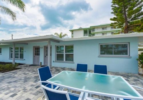 a blue house with a blue table and chairs at Sun and Sea By Beachside Management in Siesta Key