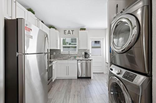 a kitchen with a refrigerator and a washer and dryer at Sun and Sea By Beachside Management in Siesta Key