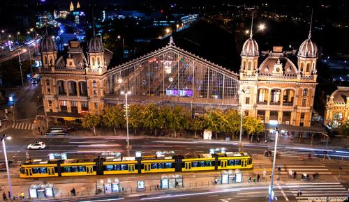 a city street with buses in front of a building at night at Little Americas Wyoming Lodge Apartment in Budapest