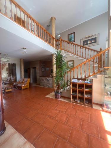 a large living room with a staircase and a floor at Hotel Gavitu in Celorio