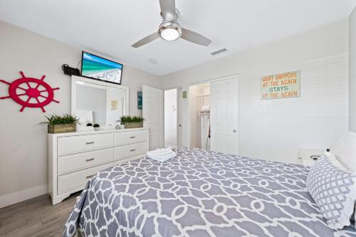 a bedroom with a bed and a nautical sign on the wall at Sun and Sea By Beachside Management in Siesta Key