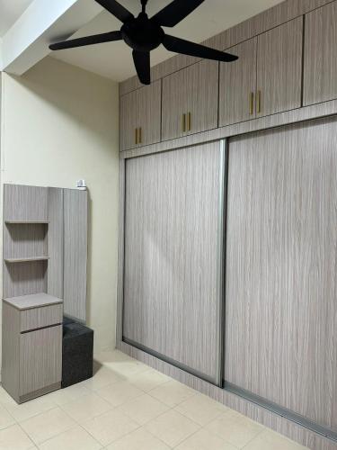 a garage with two sliding doors and a ceiling fan at Ruzarani Home Meru Suria in Chemor