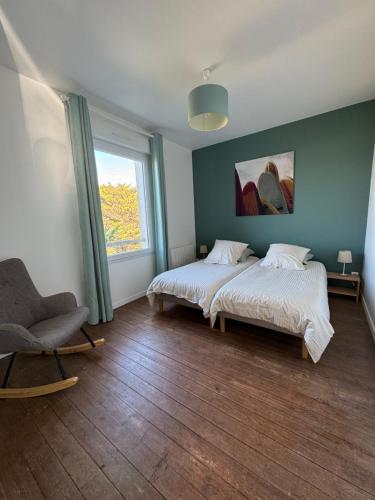 1 Schlafzimmer mit 2 Betten, einem Stuhl und einem Fenster in der Unterkunft Villa Denise Grand Gîte in Barneville-Carteret
