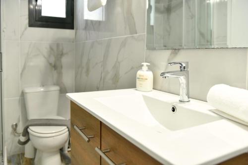 a bathroom with a sink and a toilet and a mirror at Green View Apartments in Kouspádes