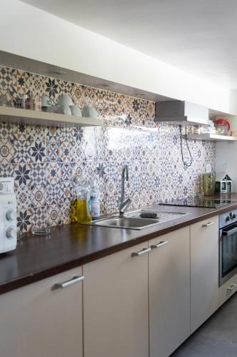 a kitchen with white cabinets and a sink at Villa Sunshine in Sremska Kamenica