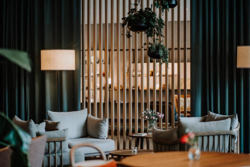 a room with chairs and tables and a large window at VillaVerde Aparthotel in Lagundo