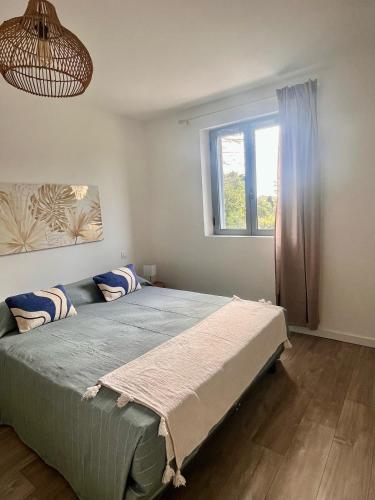 a bedroom with a bed and a window at Hôtel Résidence CAPENSE in Centuri