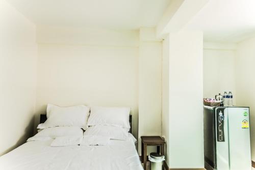 a bedroom with a bed and a refrigerator at Don Muang Hotel in Bangkok