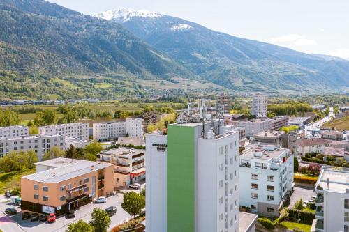 eine Luftansicht einer Stadt mit Bergen im Hintergrund in der Unterkunft Nonanteneuf Appart-hôtel - Sierre in Sierre