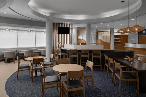 a dining room with tables and chairs and a bar at SpringHill Suites Houston Intercontinental Airport in Houston