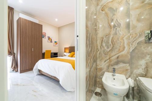 a bedroom with a bed and a bathroom with a sink at Station House 45 in Naples