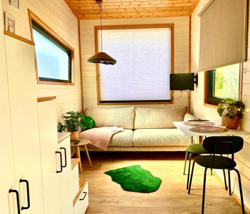 - un salon avec un canapé et une table dans l'établissement Tiny house with garden and jacuzzi near Amsterdam, à Vijfhuizen